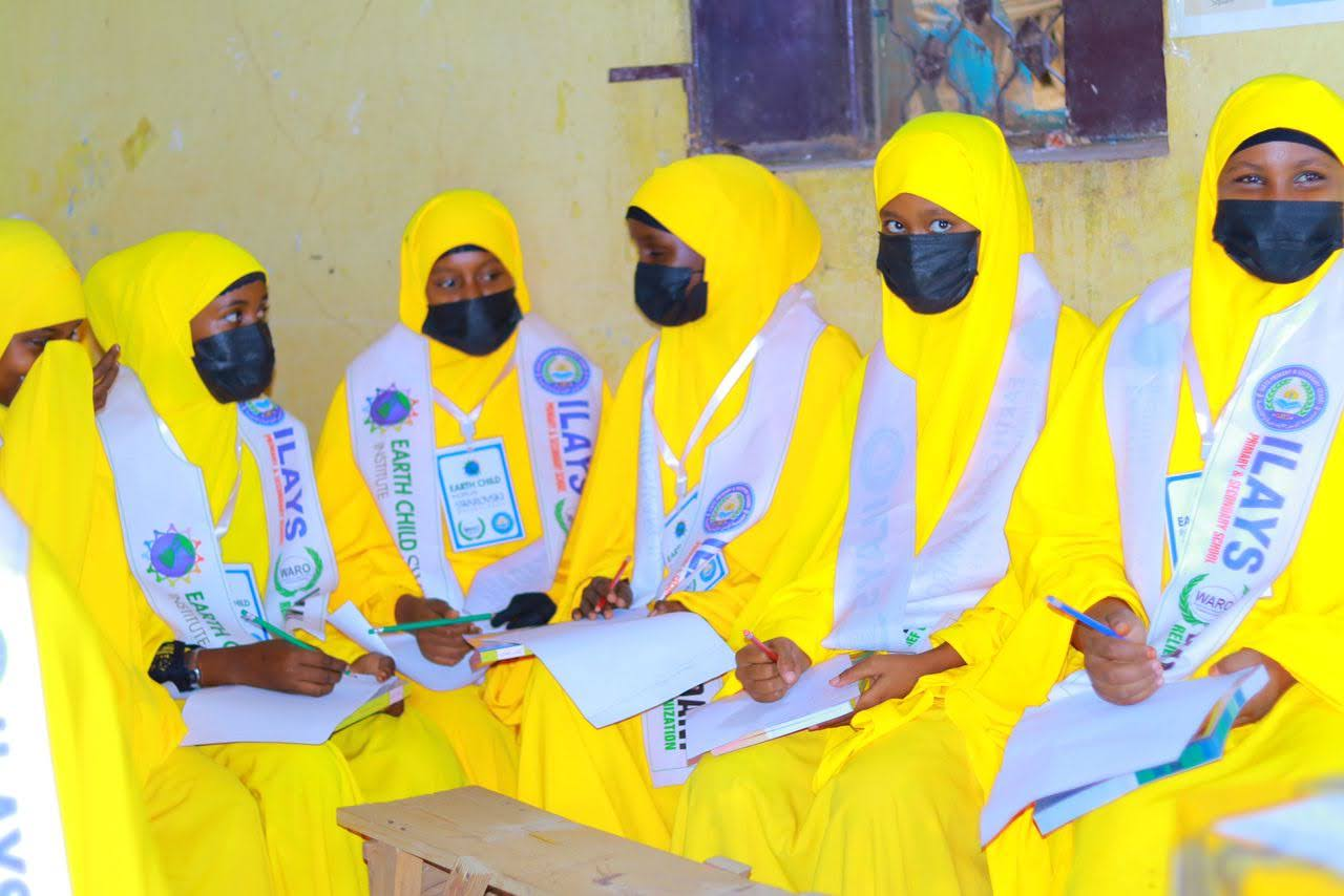 Students in yellow hijabs wearing sashes at school